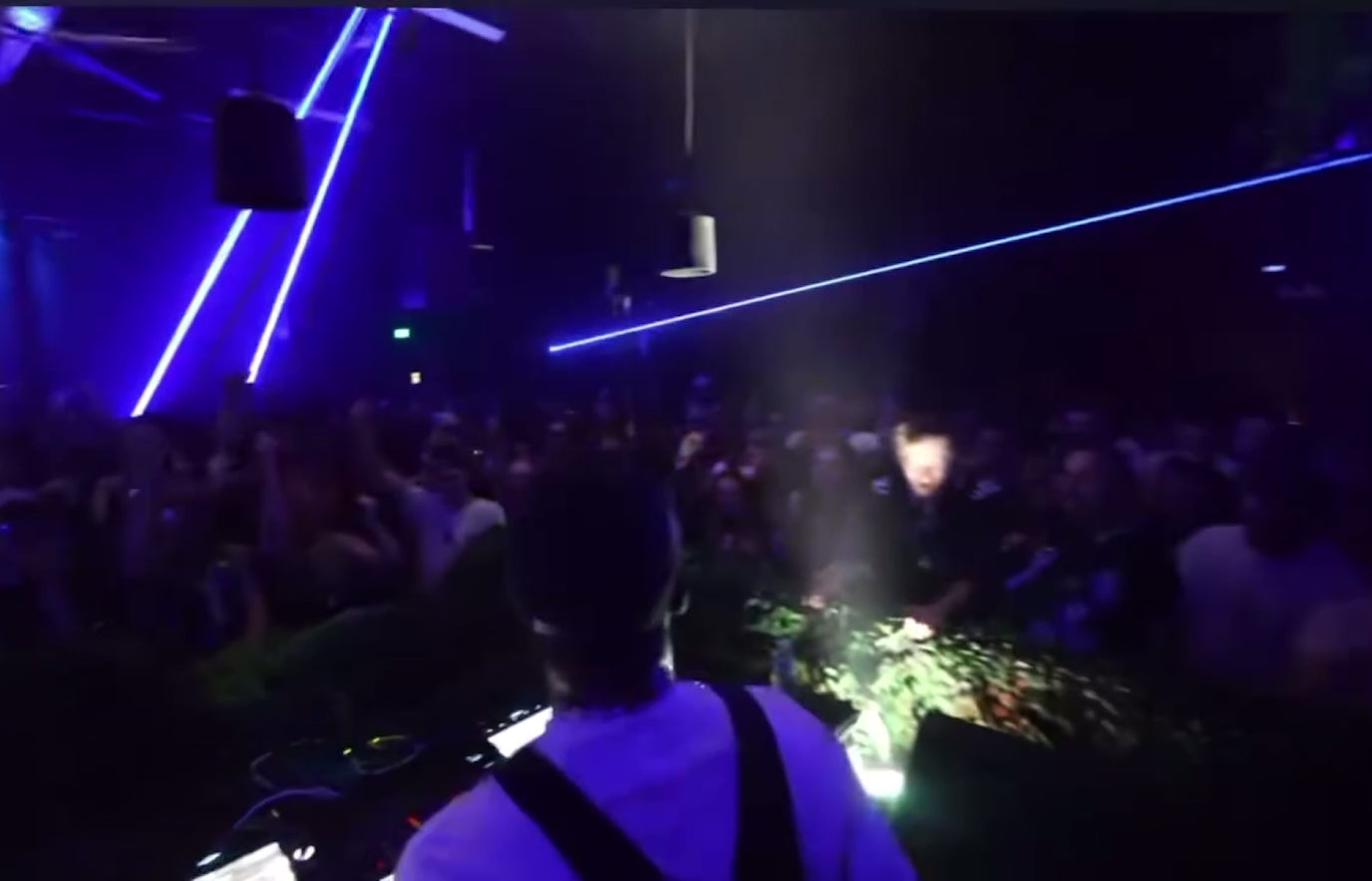 Load video: Warehouse event with a lot of happy people jumping around with lasers flying everywhere